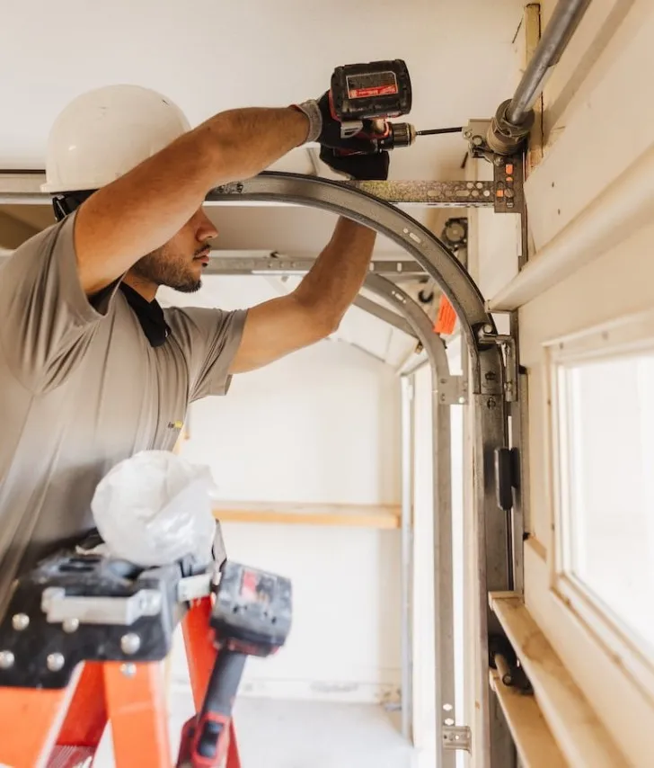 : Friendly garage door technician helping homeowner